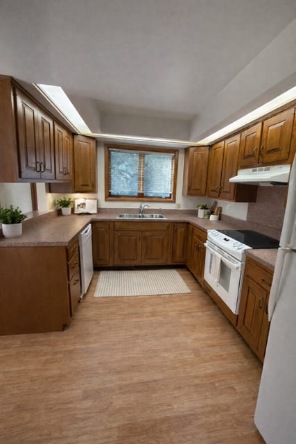 A kitchen with wooden cabinets and a white refrigerator.