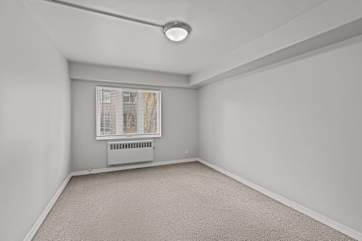 A room with a window and a carpeted floor