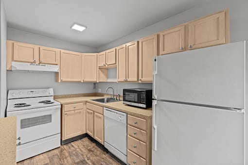 A kitchen with a white refrigerator, white oven, and wooden cabinets