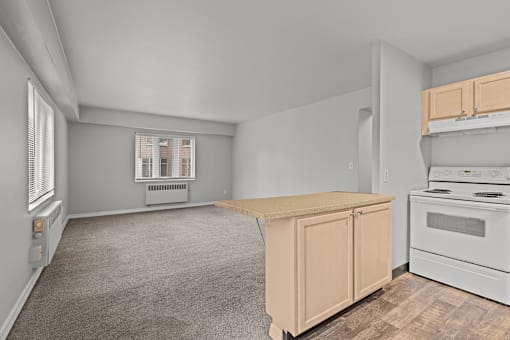 A kitchen with a white stove and a window with blinds