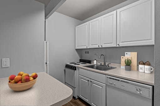 A kitchen with a bowl of fruit on the counter