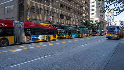 A red and yellow bus is parked on the side of the street
