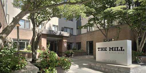 The Mill at First Hill is a modern building with a large entrance and a sign at the front.