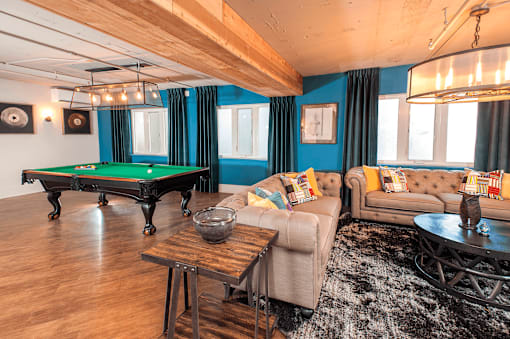 A room with couched and a pool table