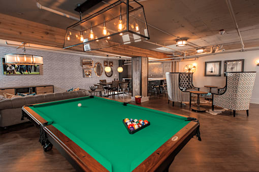 A pool table with a green felt cloth and a white cue ball in the middle