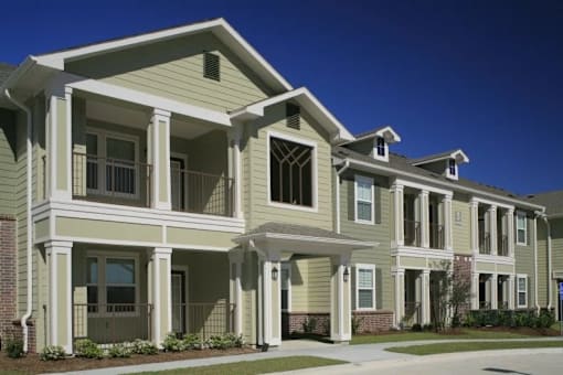 A row of townhouses with balconies and front yards.