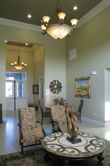 A living room with a patterned rug and a chandelier.