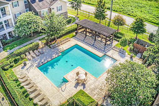 A swimming pool with a deck and a pavilion.