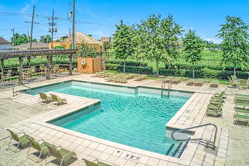 A large outdoor swimming pool surrounded by sun loungers.