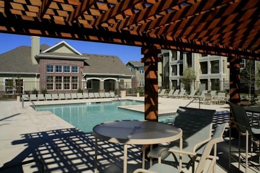 A patio with a table and chairs under a pergola.