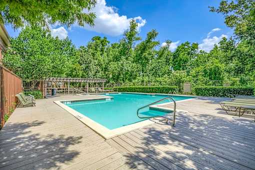 A wooden deck surrounds a rectangular pool.