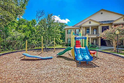 A playground with a blue slide and a red slide.