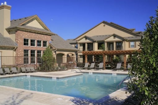 A large house with a pool in front.