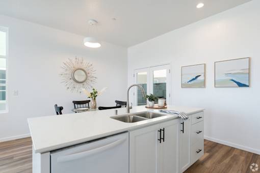 A white kitchen with a large island and a sink.