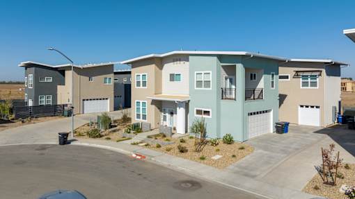 A row of modern houses with garages and driveways.