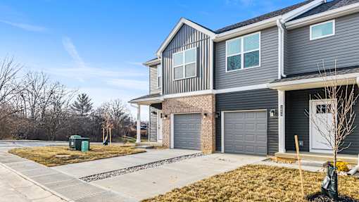 A modern two-story house with a grey exterior and a grey garage door.