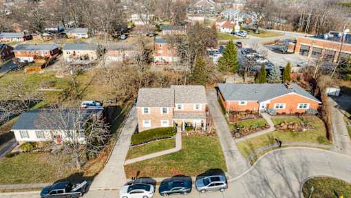 A residential area with houses and cars parked in front.