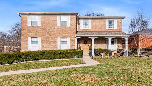 A two-story brick house with a front porch.