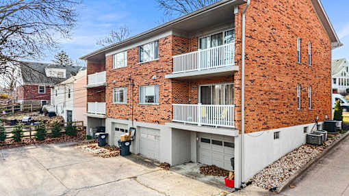 A red brick apartment building with a white garage door.