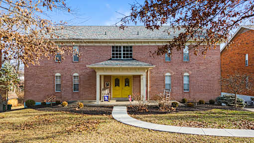A red brick house with a yellow front door.
