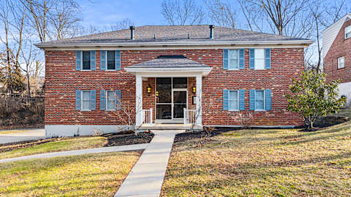 A red brick house with a white door and windows.