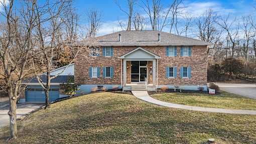 A house with a brick facade and a large front yard.