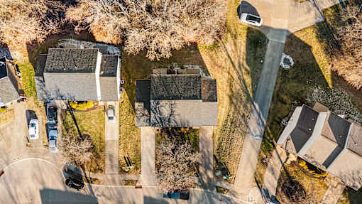 A bird's eye view of a residential area with houses and cars.
