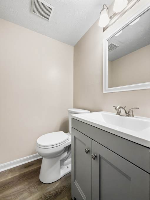A white toilet sits next to a sink in a bathroom.