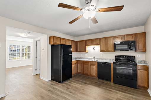 A kitchen with black appliances and wooden cabinets.