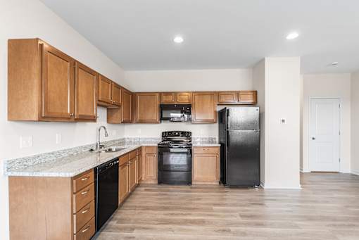 A kitchen with wooden cabinets and black appliances.