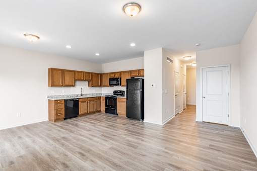 A kitchen with black appliances and wooden cabinets.