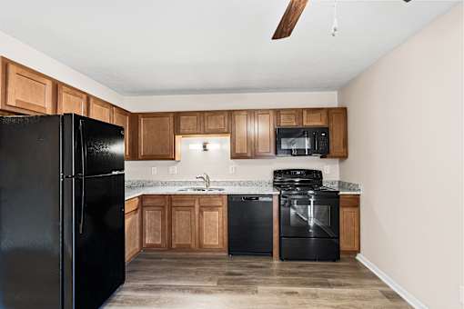 A kitchen with black appliances and wooden cabinets.