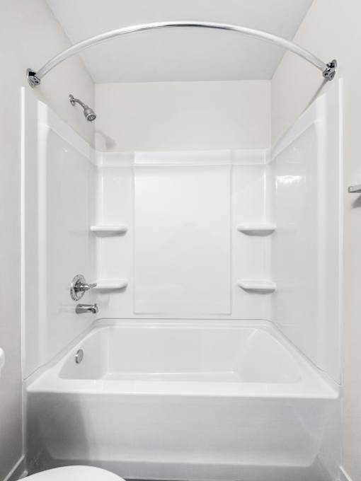 A white bathroom with a toilet and a bathtub.