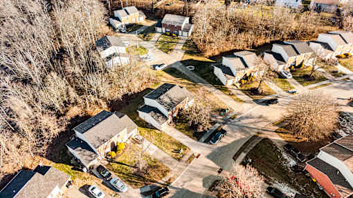 A bird's eye view of a residential area with houses and cars.
