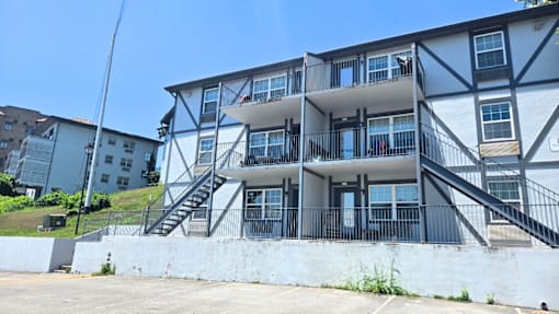 A large white building with black railings and stairs.