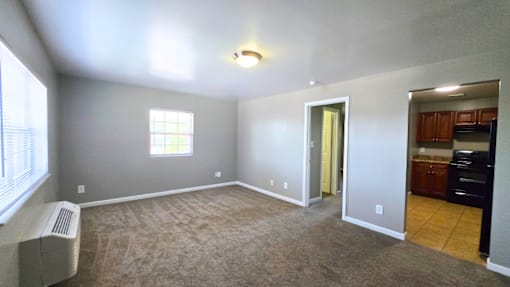 A room with a window, a door, and a heater.