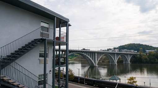 A bridge over a river with a house and stairs in the foreground.at Maplehurst Apartments, Knoxville, 37902