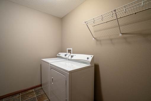 A white sink is in a small room with a wall-mounted cabinet.