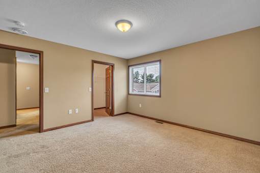 A room with a carpeted floor and a picture of a house on the wall.