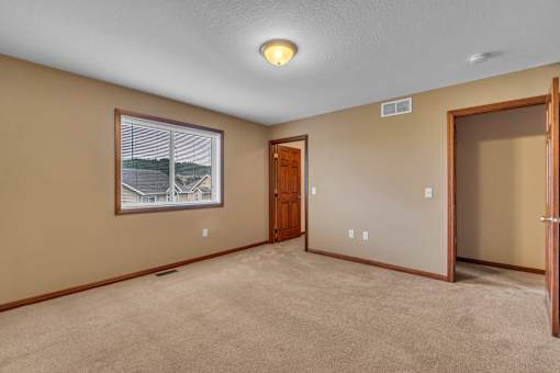 A room with a carpeted floor and a picture on the wall.