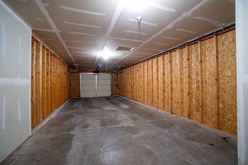 A long, empty room with wooden walls and a concrete floor.