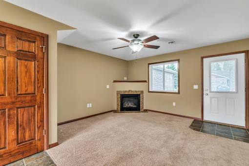 A room with a fireplace and a ceiling fan.