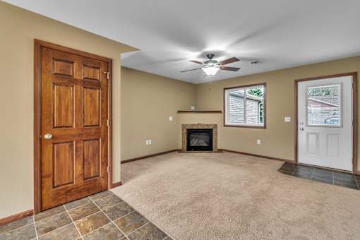 A room with a fireplace and a ceiling fan.