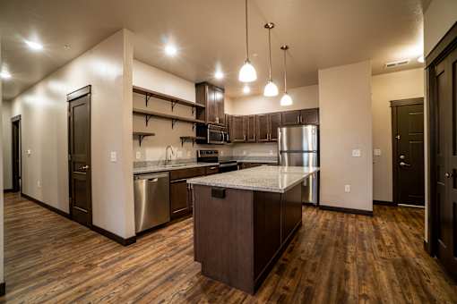 A kitchen with wooden floors and a center island.