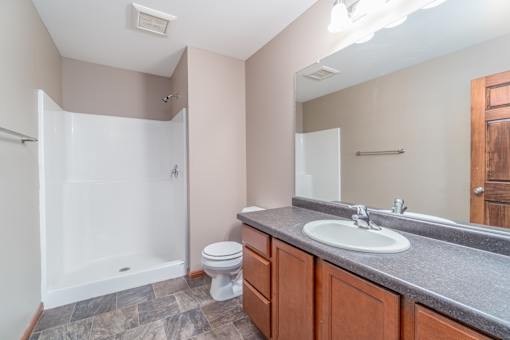 A bathroom with a toilet, sink, and shower.