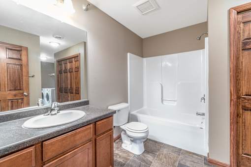 A bathroom with a white toilet and a white bathtub.
