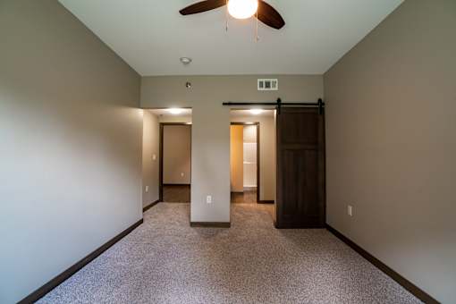 A room with a ceiling fan and two doors.