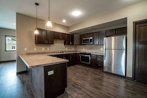A kitchen with dark wood cabinets and stainless steel appliances.