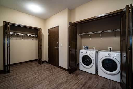 A laundry room with two washing machines and a dryer.