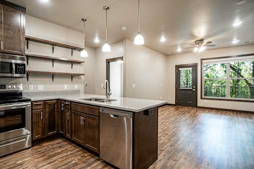 A kitchen with wooden floors and stainless steel appliances.